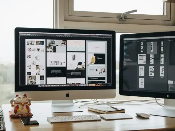 Two monitors setup next to each other on a computer desk.
